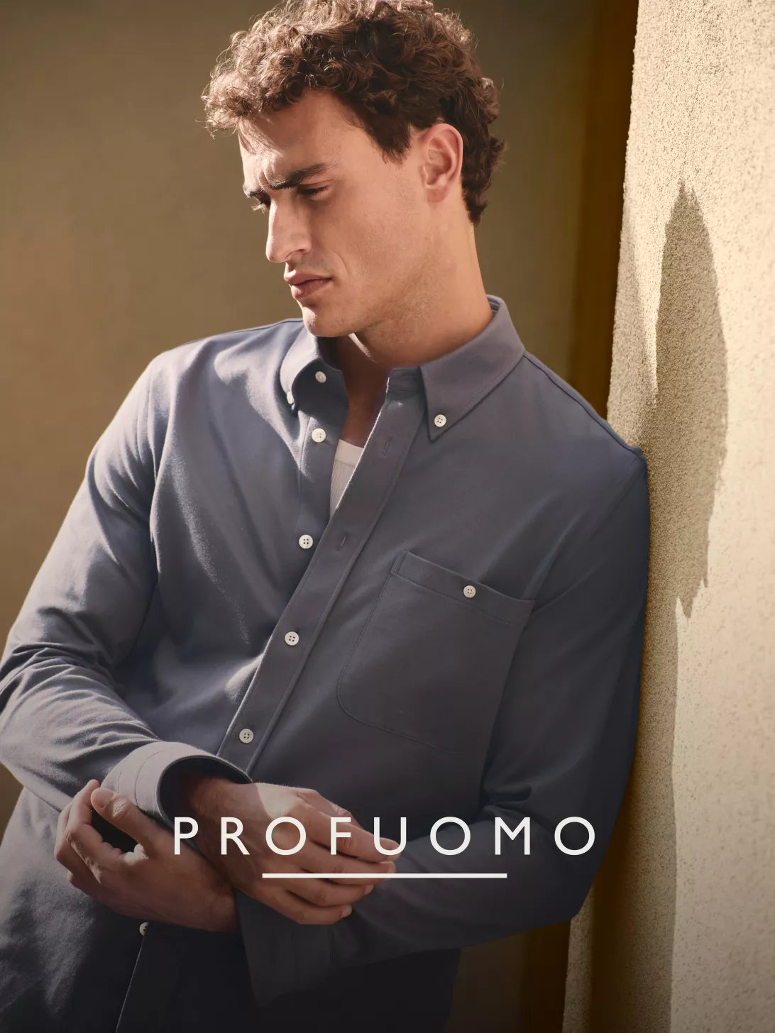 Profuomo SS26 – Modell im blauen Button-down-Hemd an einer Wand