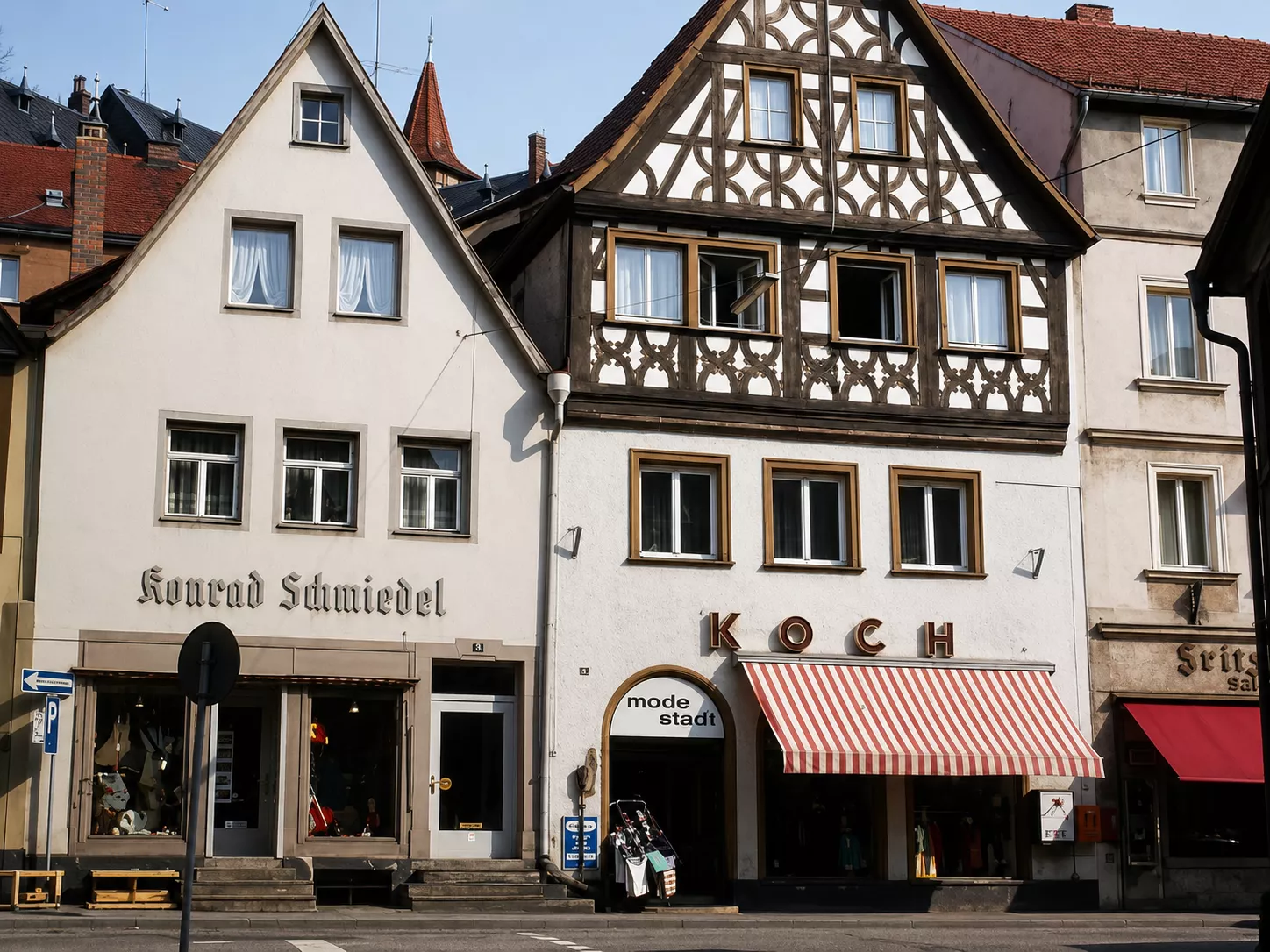 Modehaus Koch mit Fachwerkfassade und gestreifter Markise